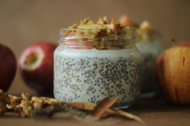 Overnight oats with apple and almonds. Made by soaking rolled oats and chia seeds in milk served with chopped apples, cinnamon, almonds and honey Overnight oats with apple and almonds. Made by soaking rolled oats and chia seeds in milk served with chopped apples, cinnamon, almonds and honey for a chilled, yummy, healthy and easy breakfast apple cinnamon pancake stock pictures, royalty-free photos & images