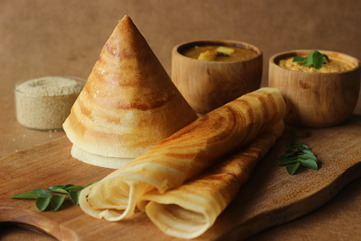 Crispy crepes made of barnyard millets and lentils. Commonly known as barnyard millet ghee roast dosa. Plated in conical shape and rolls. Served with coconut spicy condiments.