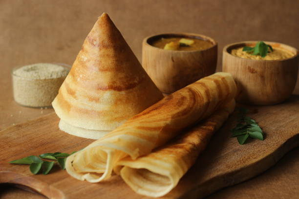 Crispy crepes made of barnyard millets and lentils. Commonly known as barnyard millet ghee roast dosa. Plated in conical shape and rolls. Served with coconut spicy condiments. Crispy crepes made of barnyard millets and lentils. Commonly known as barnyard millet ghee roast dosa. Plated in conical shape and rolls. Served with coconut spicy condiments. thosai stock pictures, royalty-free photos & images