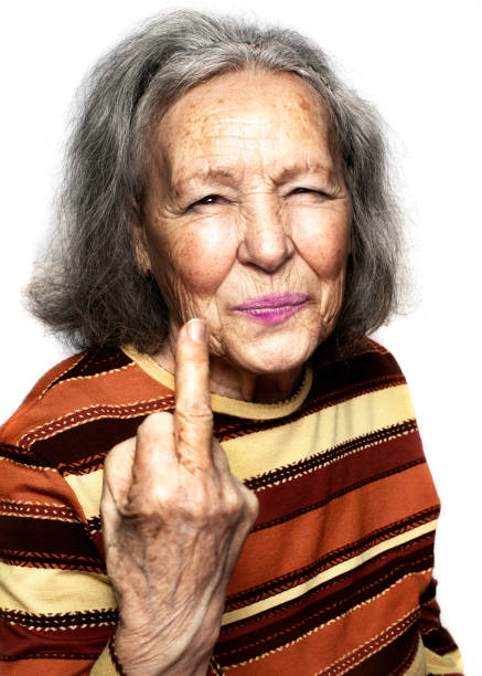 Older lady shows her middle finger in a nasty, provocative and cheeky way while she smiles looking at the camera. Fuck you concept. Fuck you concept. older lady shows her middle finger in a nasty, provocative and cheeky way while she smiles looking at the camera. Fuck you concept. ugly old women stock pictures, royalty-free photos & images