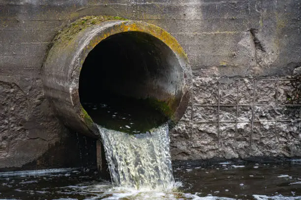 Photo of Dirty water flows from the pipe into the river, environmental pollution. Sewerage, treatment facilities