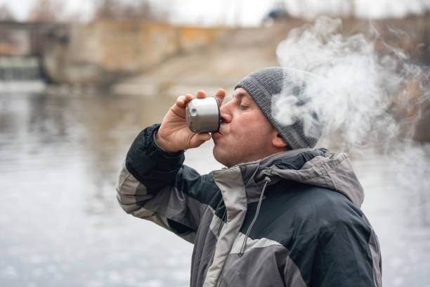 istock A man drinks hot coffee and smokes in nature, his face is covered with thick smoke 1364760798