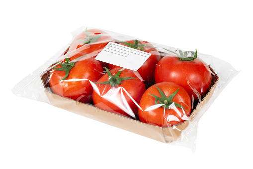 Packed and labeled fresh tomatoes on isolated white background