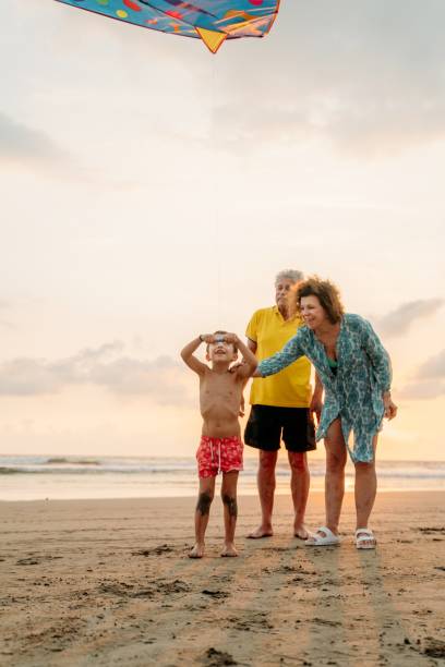 nonno che gioca con i nipoti - acapulco mexico sunset day foto e immagini stock