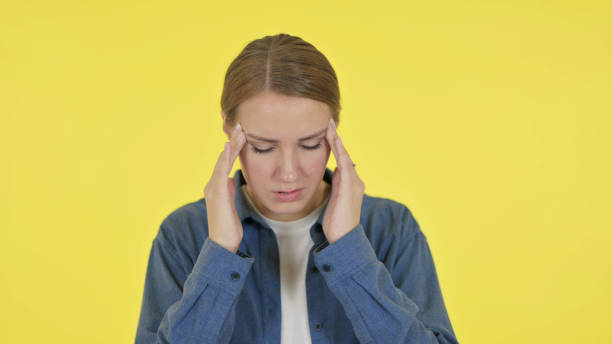 istock Young Woman having Headache on Yellow Background 1364762184