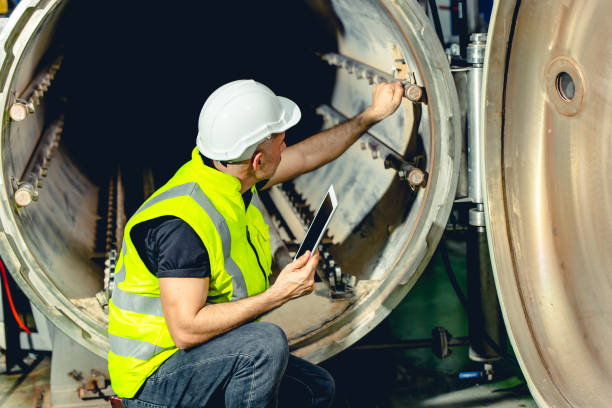 ingeniero trabajo servicio de comprobación y mantenimiento de la caldera de la industria en la fábrica pesada - giant boilers fotografías e imágenes de stock