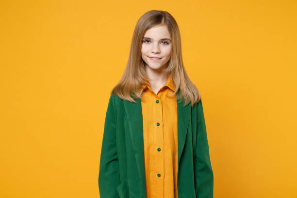 작은 금발의 귀여운 아이 소녀 12-13 세 캐주얼 옷 녹색 셔츠를 입고 노란색 오렌지 배경 어린이 스튜디오 초상화에 고립 된 미소 카메라 찾고. 어린 시절 라이프 스타일 컨셉 - teenager 14 15 years 13 14 years cheerful 뉴스 사진 이미지