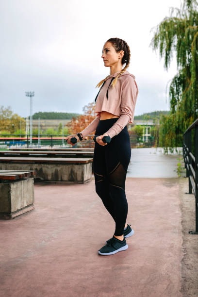 istock Young woman training with dumbbells 1364771664