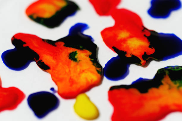 Close up of colourful ink droplets. with a white background. Close up taken with a Macro lens in the studio.