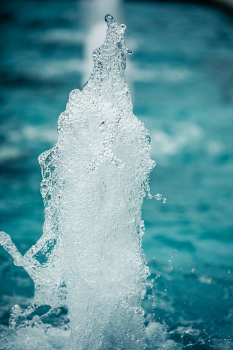 Close-up of a single water jet in a water fountain shot with a fast shutter speed creates an natural background image.