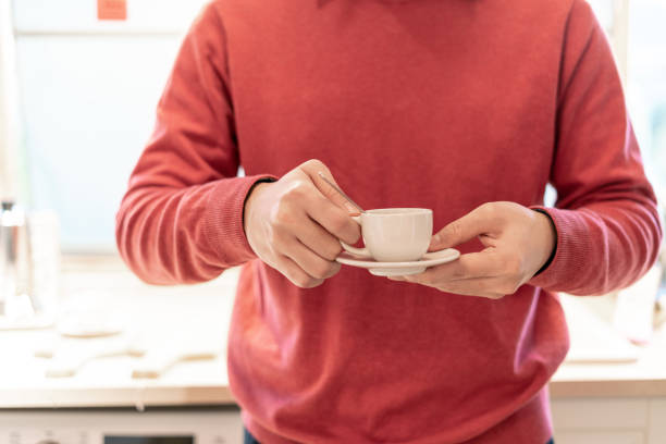 istock Young man in red sweater holding a cup of coffee 1364776723