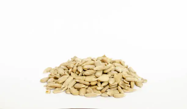 a pile of raw sunflower seeds isolated on a white background