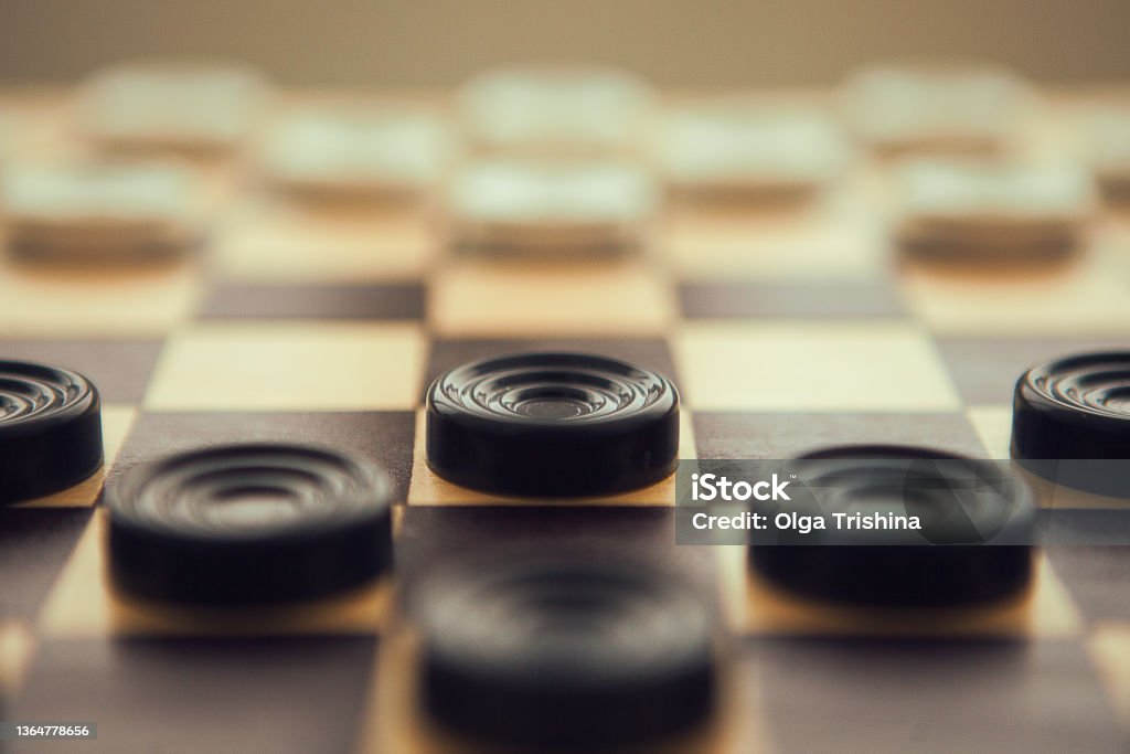 Checkers white and black on chess-board, very close up Checkers white and black on chess-board, very close up. Checkers Stock Photo