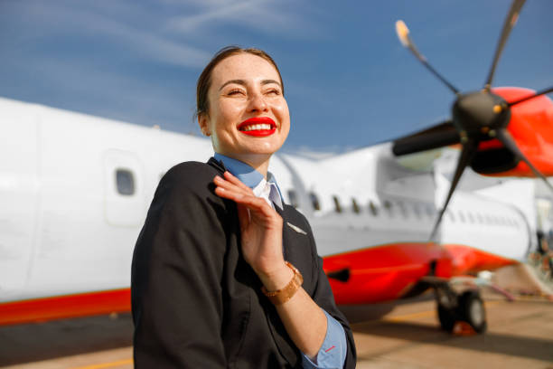 istock Cheerful woman airline worker standing outdoors at airfield 1364780308