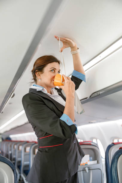 istock Stewardess demonstrating how to use oxygen mask in aircraft 1364780350