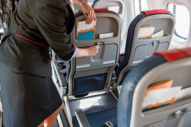 istock Female flight attendant preparing instruction brochure for passengers 1364780383