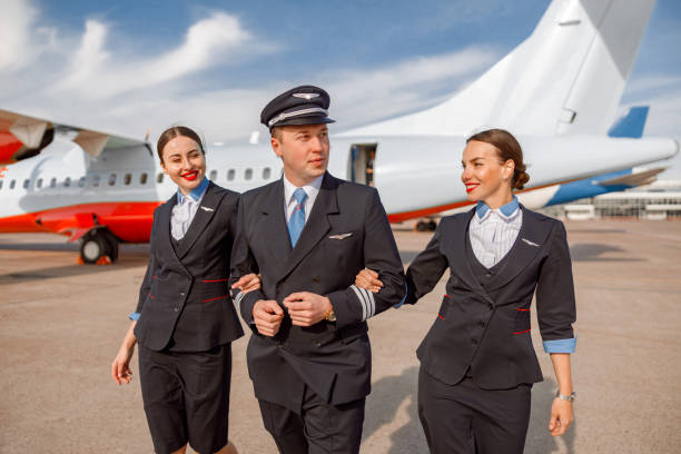 istock Aircraft pilot and flight attendants walking down airfield 1364780385