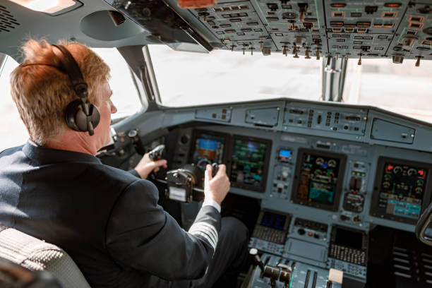 istock Male pilot controlling airplane flight from cockpit 1364780503
