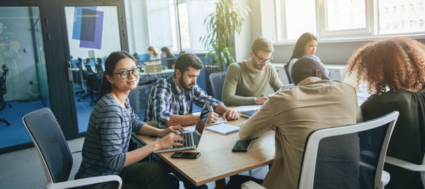 istock Hard-working team of young office workers working at desk 1364780629