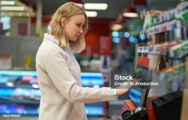 Woman Pays At Selfcheckouts In Supermarket Stock Photo - Download Image Now - Kiosk, Self Service, Store