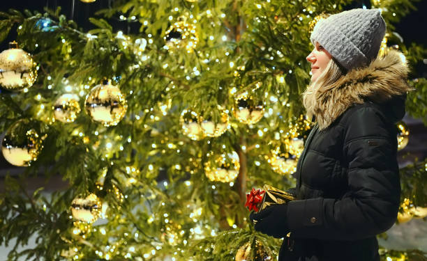 istock Woman with gift waiting near Christmas tree. 1364780685