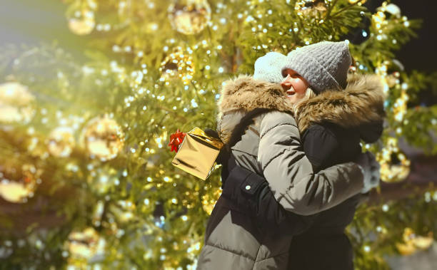 istock Mom and daughter with Christmas presents under the tree. 1364780696