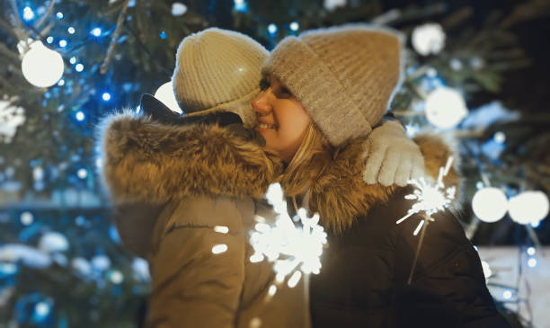 istock Family with bengal fire is hugging next to a Christmas tree. 1364780698
