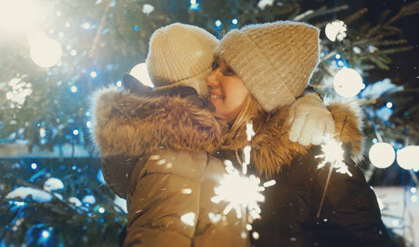 istock Family with bengal fire is hugging next to a Christmas tree. 1364780708