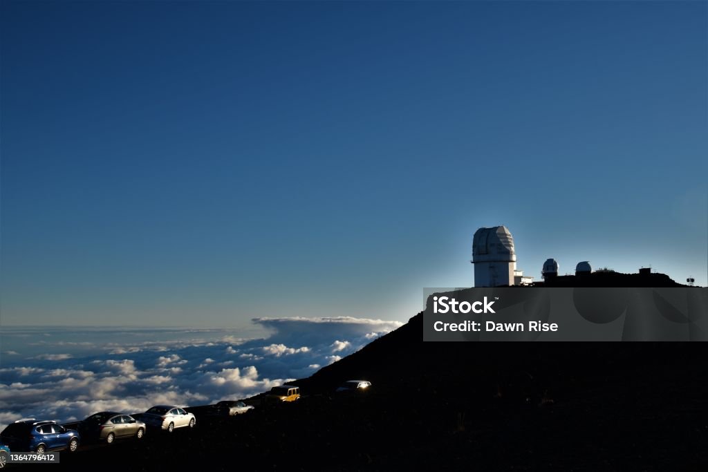 Observatory at the summit of Haleakala Tourists gather at the summit. Temperatures in August had dropped to the 40s here. Cloud - Sky Stock Photo