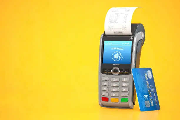 Photo of POS point of sale terminal for credit card payment on yellow background.