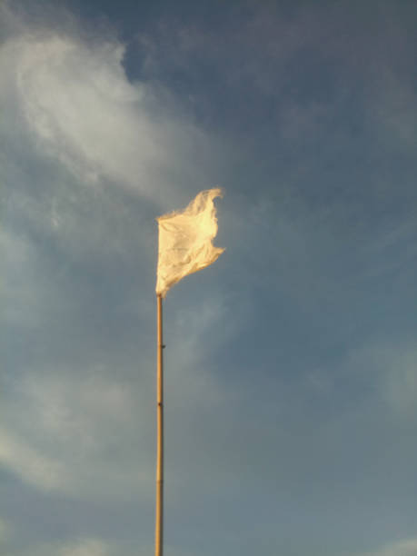 istock waving white flag against the blue sky background. 1364798610