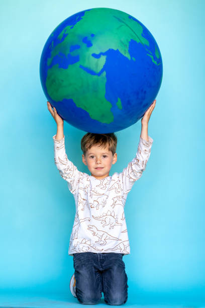 istock Little boy carrying the earth on his head 1364798701