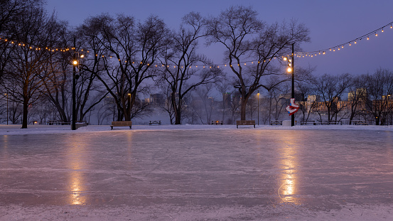 Outdoor skating rink on Île Sainte-Helène with a view of downtown, a freezing morning, St. Lawrence River, Montreal, Quebec, Canada