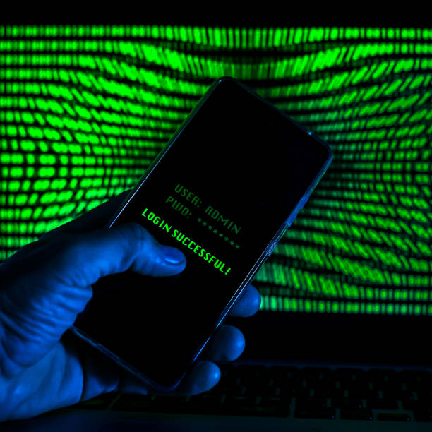 istock Hand with smartphone doing successful login in a digital network. Display with green numbers in background. Hacker forced the system. Technology, communication, security, protection, intrusion concept 1364799890
