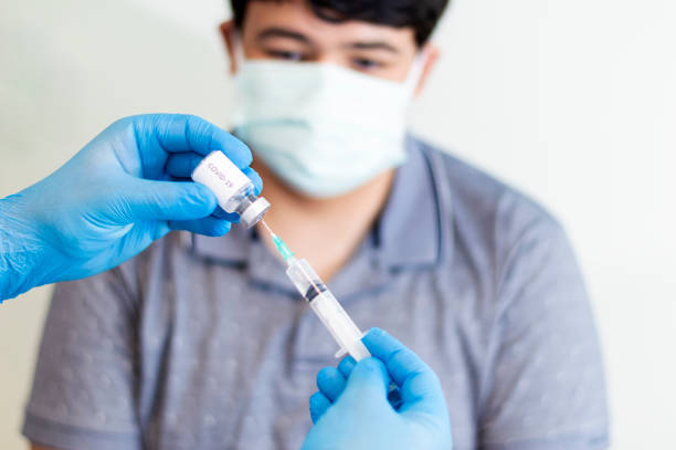istock Infectious doctor preparing COVID-19 vaccine for patient. 1364802361