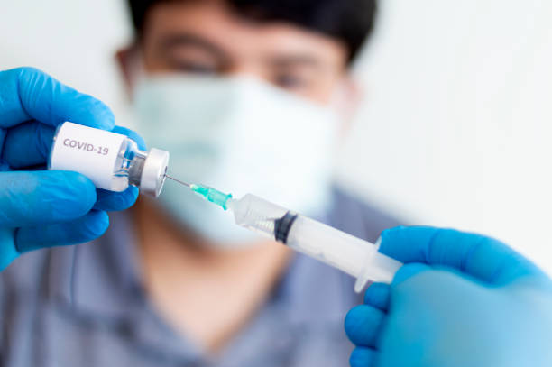 istock Infectious doctor preparing COVID-19 vaccine for patient. 1364802767