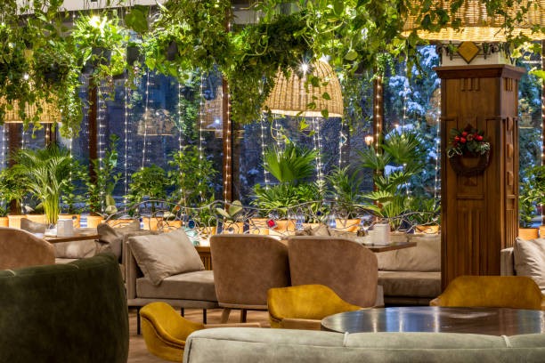 istock Modern classic restaurant interior with big glass windows and green live plants. 1364811957