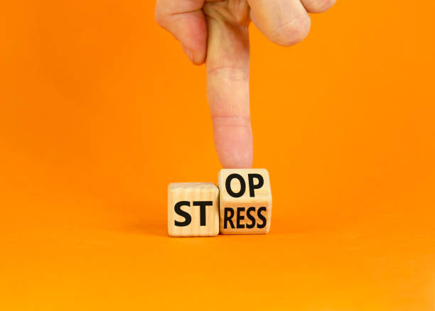 Stop stress and be health symbol. Doctor turns a wooden cube and changes words 'stress' to 'stop'. Beautiful orange background. Psychological, business and stop stress concept. Copy space. stock photo