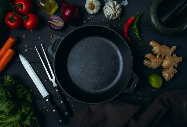 istock Cast iron brazier, with ingredients, kitchen utensils, for cooking, on a dark gray wooden table, top view, horizontal, tinted, rustic style,no people, 1364815264