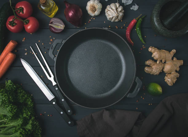 istock Cast iron brazier, with ingredients, kitchen utensils, for cooking, on a dark gray wooden table, top view, horizontal, tinted, rustic style,no people, 1364816373