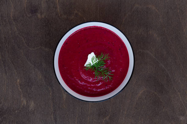 vegetable soup with greens. Bowl of Beetroot cream soup on a brown wooden background. Healthy dietary lunch. Flat lay, top view. copy space