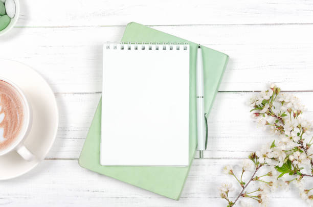 Creative flat lay of workspace desk, notepad on wooden background