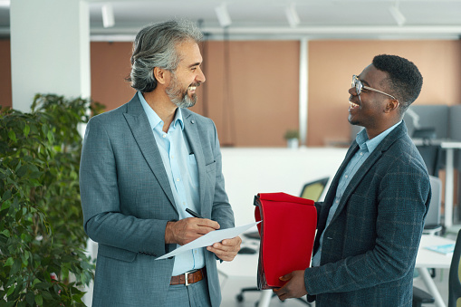 Closeup of a mid aged man acting as a creative director at a design studio choosing textile for the new furniture collection. Young African American man is presenting different materials and colors