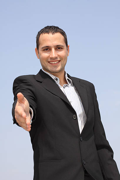 Smiling businessman giving hand for an handshake stock photo