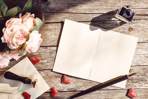 バレンタインデーのテーマ。ラブレター、インク、万年筆、バラ、ヴィンテージの木製テーブルの封筒のトップビュー。テキストのスペース。 - paper sheet ストックフォトと画像
