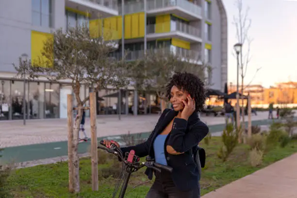 Young black woman casually dressed going to work in a bike