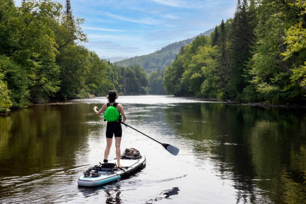 femme paddleboard sur la rivière en été - paddle surfing photos et images de collection