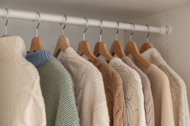 istock Warm beige wool pullover and knitwear and hanging in wardrobe 1364829667