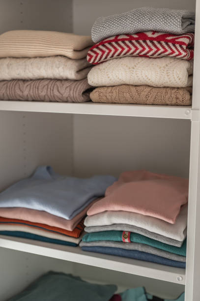 istock Pastel clothes folded on shelves in wardrobe 1364829715