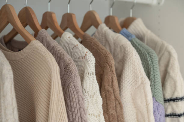 Warm beige wool pullover and knitwear and hanging in wardrobe stock photo